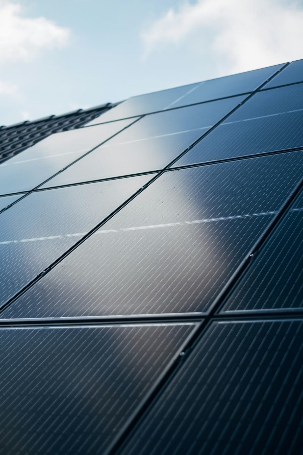 Close-up van zonnepanelen op een woningdak met dakpannen